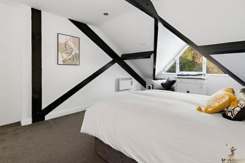 una camera da letto con un grande letto bianco e una finestra di 3A St Anne's Well Brewery City Centre, Parking a Exeter