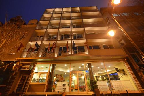 un grand bâtiment avec des drapeaux devant lui dans l'établissement Best Western Hotel Turist - Superior, à Skopje