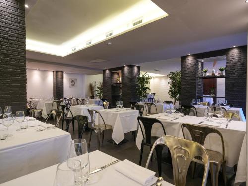 a dining room with white tables and chairs at La Meridiana Bleisure Hotel in Perugia