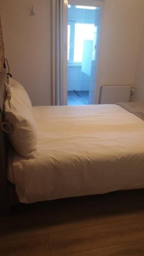 a white bed in a room with a window at Hotel B&B Sint-Maria NEXT DOOR in Valkenburg