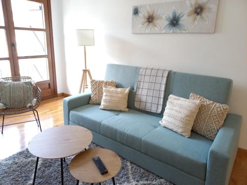 a living room with a blue couch and a table at BPIRINEOS-Parque Los Tilos 2 in Benasque
