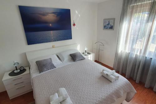 1 dormitorio con 1 cama blanca y una gran pintura en la pared en Apartment Marija for three Persons Valbandon close to the beach, en Valbandon