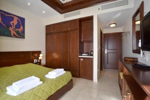 1 dormitorio con 1 cama verde y cocina en Alexander Mountain Resort, en Yerakárion