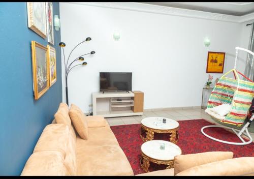 a living room with a couch and a tv at DUPLEXE HAUT STANDING centre ville Quartier Fouda in Yaoundé