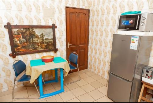 a small kitchen with a table and a refrigerator at DUPLEXE HAUT STANDING centre ville Quartier Fouda in Yaoundé
