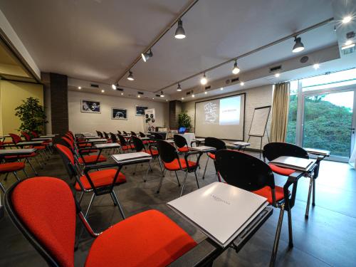 a classroom with desks and chairs and a screen at La Meridiana Bleisure Hotel in Perugia