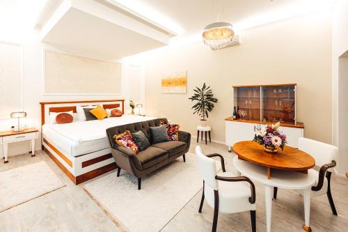 1 dormitorio con cama, mesa y sofá en Hotel Baltaci Atrium, en Zlín