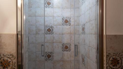 a shower with a glass door in a bathroom at CASA LA FENICE 8&2, Emma Villas in Pomarance