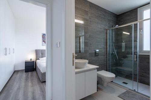 a bathroom with a shower and a toilet and a sink at Sunflower 1-Bedroom Apartment in Larnaca in Larnaka