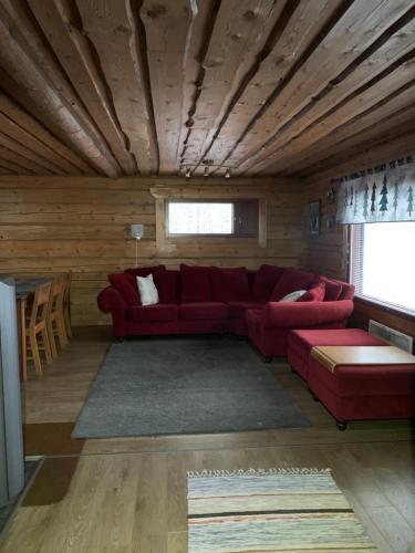 - un salon avec un canapé rouge et des plafonds en bois dans l'établissement Sampo Chalet with Hot Tub, à Ranua
