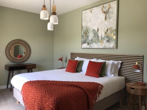 una camera da letto con un grande letto bianco con cuscini rossi di White Swan Cottage, Ashlin Farm Barns a Lincoln