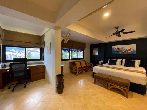 a bedroom with a bed and a desk and a chair at Summer Breeze Hotel in Patong Beach