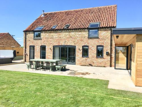una casa in mattoni con un tavolo da picnic in un cortile di Meadowsweet Barn, Ashlin Farm Barns a Lincoln