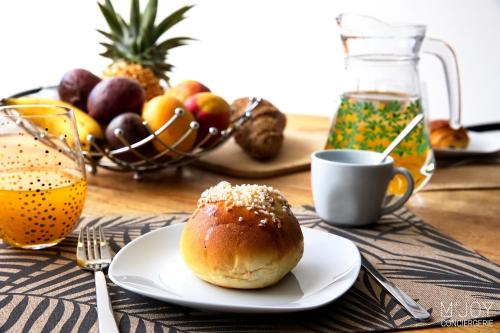 a table with a plate of bread and a cup of coffee at Ylangae DODO avec Jacuzzi à 150m du lagon in Saint-Leu