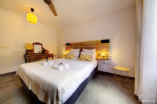 a bedroom with a large bed with towels on it at Ylangae DODO avec Jacuzzi à 150m du lagon in Saint-Leu