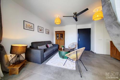 a living room with a couch and a table at Ylangae DODO avec Jacuzzi à 150m du lagon in Saint-Leu