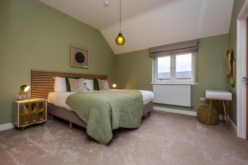 a green bedroom with a bed and a window at The Sycamores, Ashlin Farm Barns in Lincoln