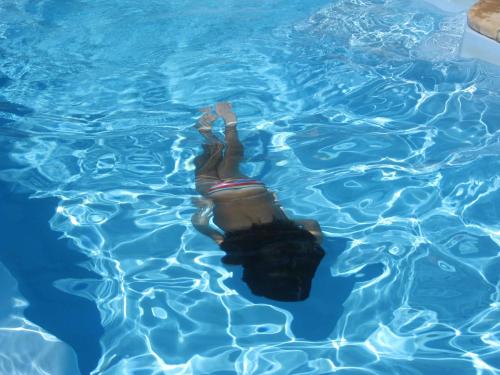 a woman is swimming in a swimming pool at Hotel Villa Belfiori in Torre Dei Corsari