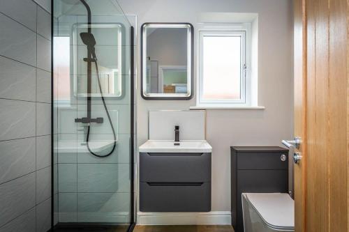 a bathroom with a glass shower and a sink at The Sycamores, Ashlin Farm Barns in Lincoln