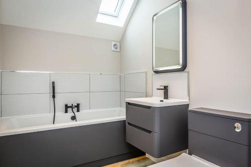 un bagno con lavandino e vasca da bagno di The Willows, Ashlin Farm Barns a Lincoln