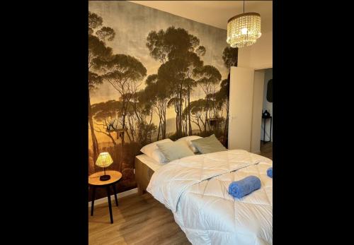 1 dormitorio con 1 cama con una pintura en la pared en Le Henry au coeur de la vieille ville, en Boulogne-sur-Mer