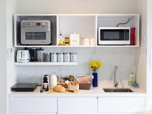 a kitchen with a counter with a microwave and appliances at Hanging Rock Views in Woodend