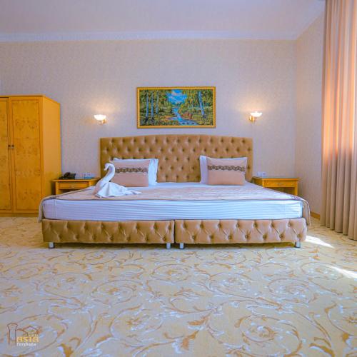 a bedroom with a large bed with a swan on it at Asia Hotel Fergana in Fergana