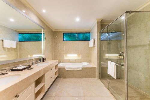 a bathroom with two sinks and a shower at Vinpearl Resort & Spa Nha Trang Bay in Nha Trang