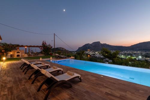 a villa with a swimming pool at night at Villa Kamos in Archangelos