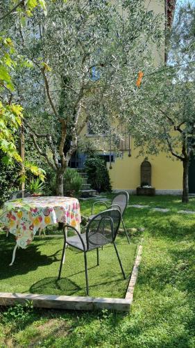 una mesa y sillas en un patio con un árbol en Casa Elsa, en Torri del Benaco
