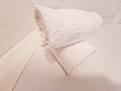 a white towel sitting on the floor of a bathroom at Sophien Hotel in Frankfurt/Main