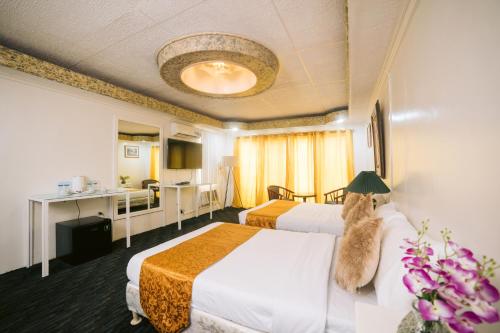 Balanga的住宿－Grand Peninsula Suites，一间酒店客房,房间内设有两张床
