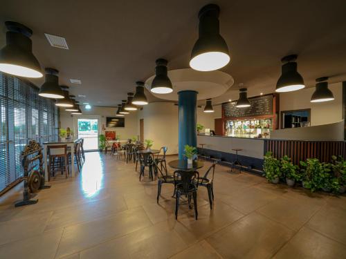 a restaurant with tables and chairs and a bar at La Meridiana Bleisure Hotel in Perugia