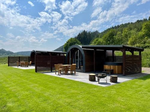 a pavilion with a table and chairs in the grass at Yr Onnen in Oswestry