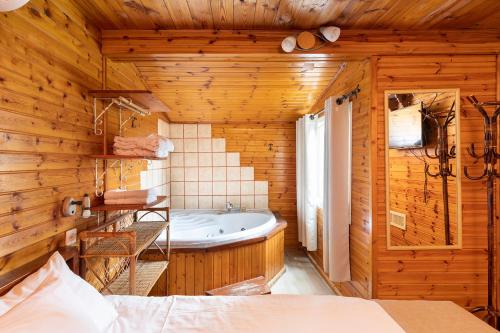 a bathroom with a tub in a wooden wall at Nof kinnert in Moshav Ramot