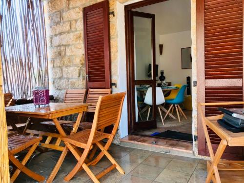 a wooden table and chairs on a patio at Place San Pantaléo : jolie maison sarde authentique in San Pantaleo