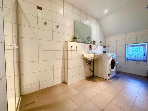 uma casa de banho com uma máquina de lavar roupa e um lavatório em Haus Elisabeth em Bad Salzungen