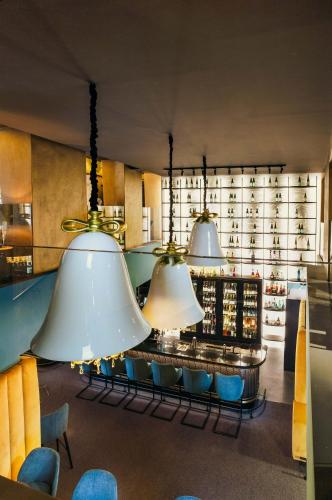 a restaurant with three large lights hanging from the ceiling at Aiola Living Graz in Graz