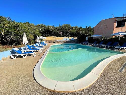 a large swimming pool with lounge chairs and umbrellas at Affittimoderni Santa Maria Coghinas in Santa Maria Coghinas