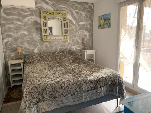une chambre avec un lit et un miroir au mur dans l'établissement Jardin D'Azur proche mer, à Cagnes-sur-Mer