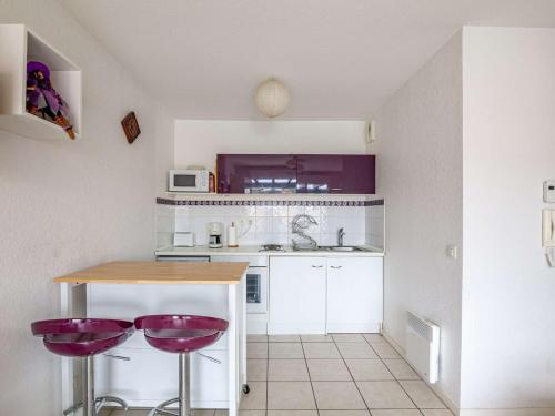 une cuisine avec tabourets de bar violet et comptoir dans l'établissement Calme et proche plage avec parking à Hendaye - FR-1-2-327, à Hendaye