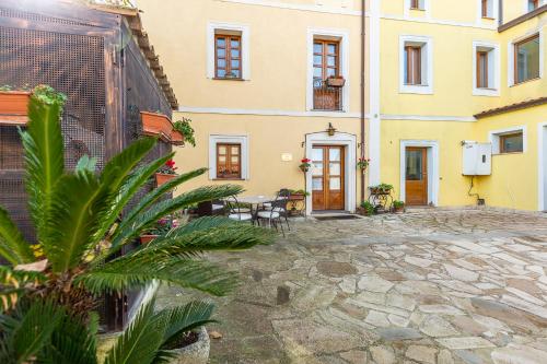 a courtyard of a building with a table and chairs at Affittacamere Is Coronas in Ìsili