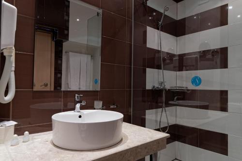 a bathroom with a white sink and a shower at Hotel Slavey - All Inclusive in Golden Sands