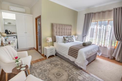 a bedroom with a bed and a chair and window at Mirihof Retreat and Olive Estate in Montagu