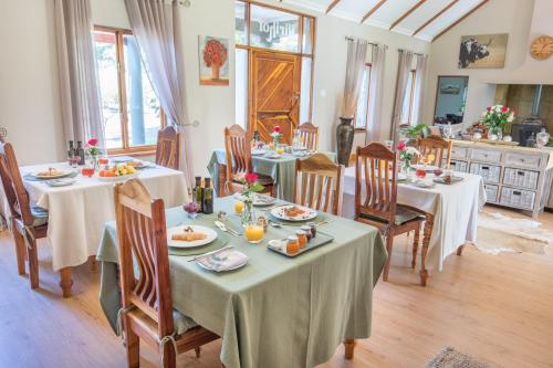 uma sala de jantar com mesas e cadeiras com comida em Mirihof Retreat and Olive Estate em Montagu