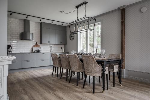 uma cozinha com uma mesa de jantar preta e cadeiras em Trädgårdsmästarbostaden / The Gardeners Villa em Gävle