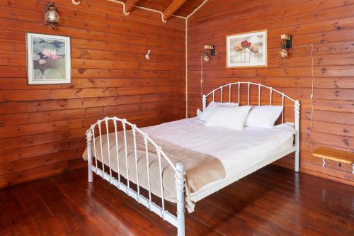 una camera da letto con letto bianco in una camera in legno di Nof kinnert a Moshav Ramot