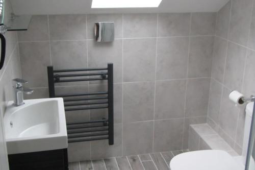 a bathroom with a sink and a toilet and a shower at The Stables, Lower Mill Estate in Somerford Keynes