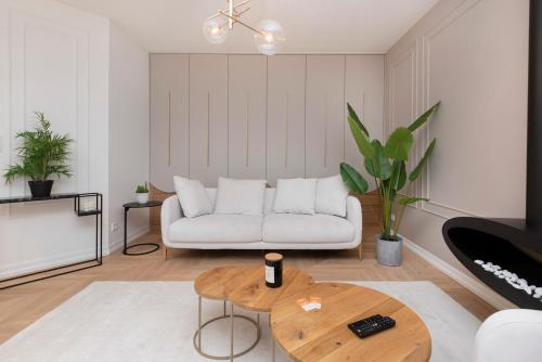 a living room with a white couch and a table at Gdańsk Tarasy Bałtyku by Renters Prestige in Gdańsk