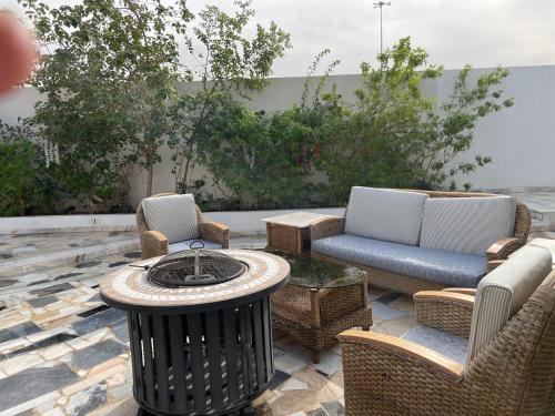 un patio con sillas y una mesa con fogata en سمو1, en Riad